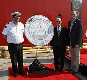 From left to right: Assistant Commissioner of the Canadian Coast Guard Wade E. Spurrell, Royal Canadian Mint Chair James B. Love and MP Jeff Watson (Essex) unveil a $20 fine silver collector coin celebrating 50 years of the Canadian Coast Guard at the Government Wharf in Sarnia, Ontario (July 13, 2012)